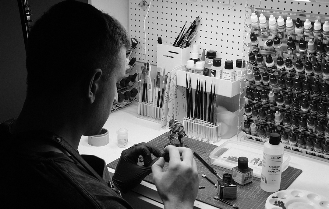 Zenon painting Warhammer miniature at workbench